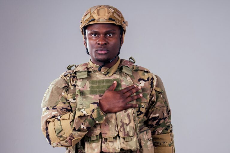 Individual wearing a MultiCam pattern field uniform, protective helmet, and load-bearing equipment, representing preparedness, interoperability, field attire standards, and operational readiness.