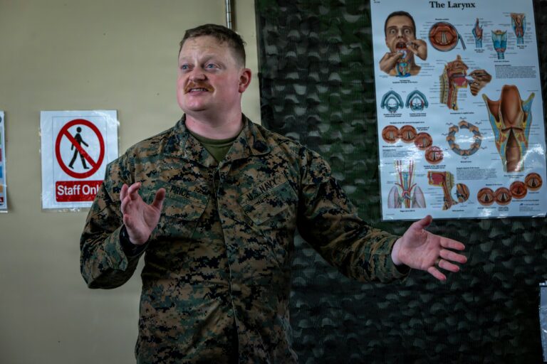 Instructor teaching medical preparedness and emergency response concepts during a classroom training session with an anatomy and airway management chart.